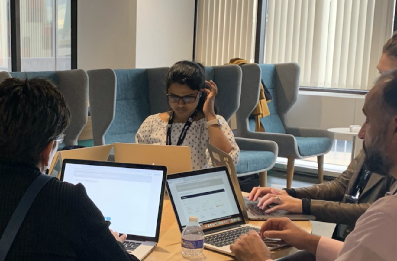 User testing session — participant working on a laptop, observers taking notes